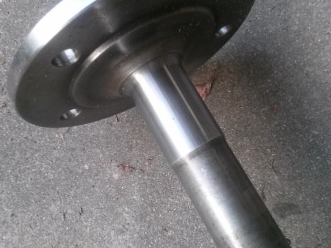 1996 Ford Bronco - Close-up of a metal axle shaft with a bolted flange, likely for a vehicle's rear end.