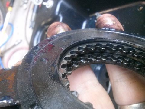 1996 Ford Bronco - A close-up view of greasy gears and a toothed metal ring, likely a vehicle part.