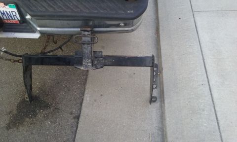 1995 Ford Bronco - The rear of a vehicle is shown with a trailer hitch assembly attached to the bumper.