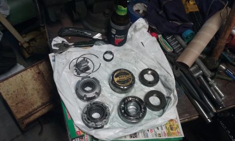 1995 Ford Bronco - Various internal transmission components are spread out on a white plastic sheet, ready for assembly or repair.