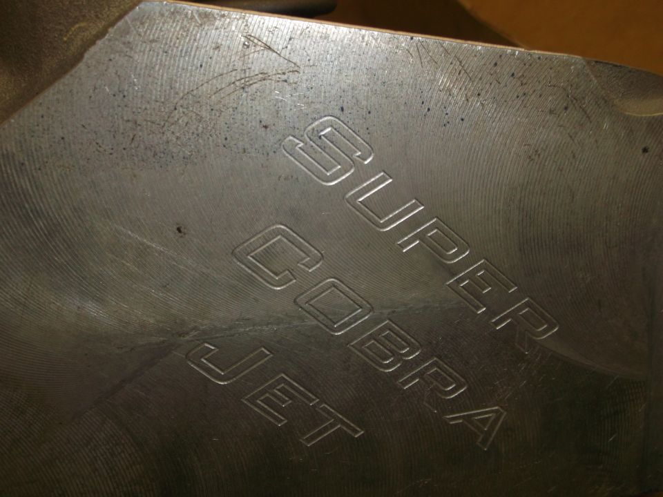 Metal engine part engraved with "SUPER COBRA JET"