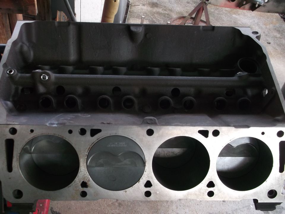Engine block with pistons visible, showing cylinder bores