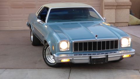 1975 Chevrolet Chevelle - This 1976 Chevrolet Nova is parked in front of a garage with its headlights on.