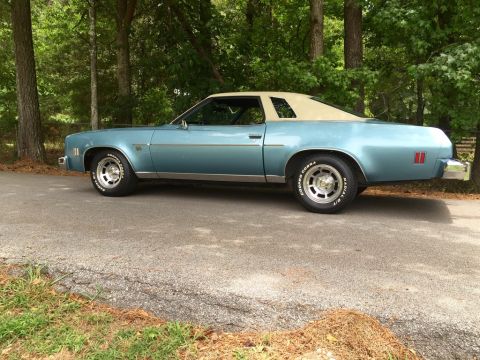 1975 Chevrolet Chevelle - Side view of a 1975 Chevrolet Chevelle coupe with a tan vinyl roof, parked outdoors.
