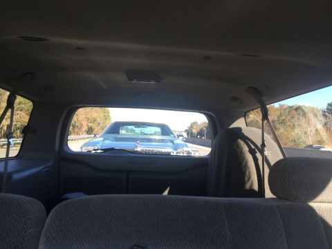 1975 Chevrolet Chevelle - View of a classic car's front end from the interior of a following vehicle on the highway.