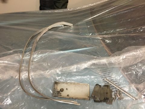 1975 Chevrolet Chevelle - Various car parts, including a hood and trim, are covered in plastic sheeting.
