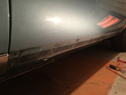 1975 Chevrolet Chevelle - The lower body panel of a car shows signs of rust and damage, with a partial taillight visible.