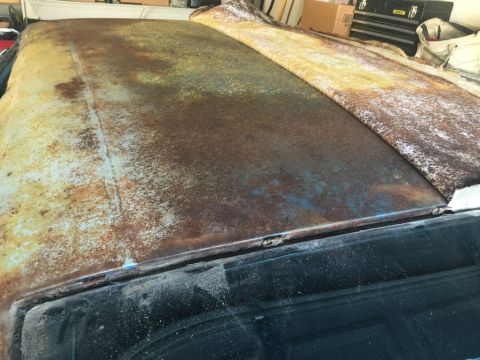 1975 Chevrolet Chevelle - The vehicle's roof shows significant rust damage and is partially covered by a tarp.