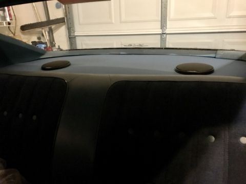 1975 Chevrolet Chevelle - The interior of a car shows black upholstered seats and two round speakers mounted on the rear deck.