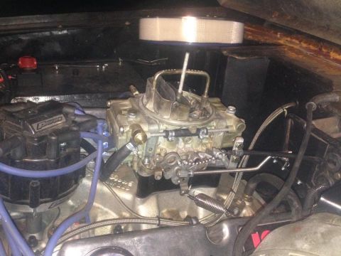 1972 Ford Bronco - Close-up view of a vehicle's engine bay, focusing on the carburetor and related components.