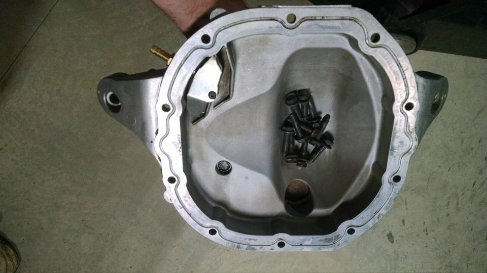 Differential cover removed, showing internal cavity with a pile of bolts and a brass fitting