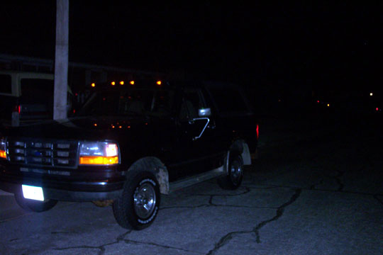 1995 Ford Bronco parked at night, front 3/4 view