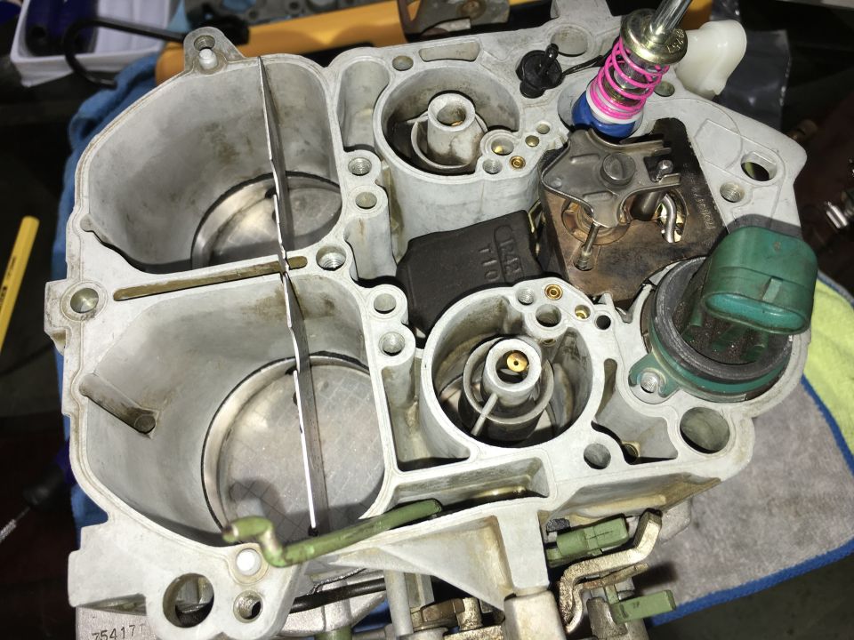 Internal view of a carburetor with visible metal and plastic components.