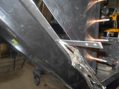 1992 Ford Bronco - A close-up view shows a metal bracket being held in place with locking pliers against a black vehicle component. Several copper rivets are…