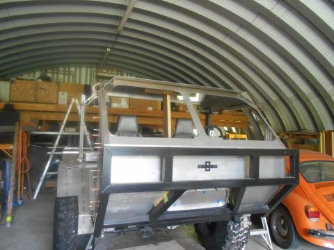 1992 Ford Bronco - A custom-built off-road vehicle, possibly a heavily modified Jeep or similar chassis, is under construction inside a metal Quonset hut gara…