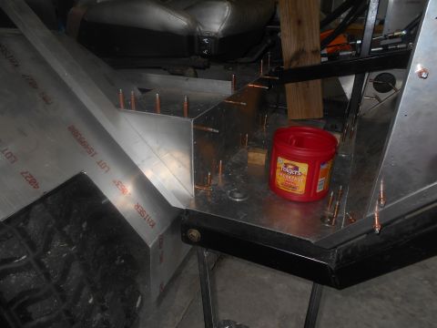 1992 Ford Bronco - The interior of a vehicle build shows unfinished aluminum panels being riveted together, with a red Folgers coffee container placed on the…