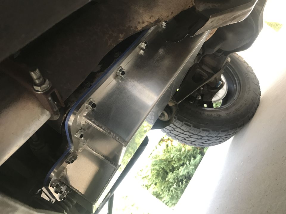 Underside of a vehicle with an aluminum skid plate installed.