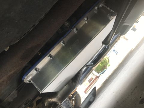 1995 Ford Bronco - An underside view of a vehicle shows an aftermarket aluminum skid plate with the brand name 'MOROSO' visible. The skid plate is secured wit…