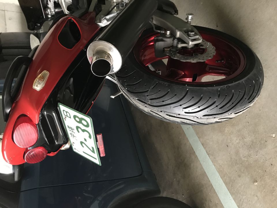 Rear view of a red and black motorcycle with a license plate reading '12-38'.