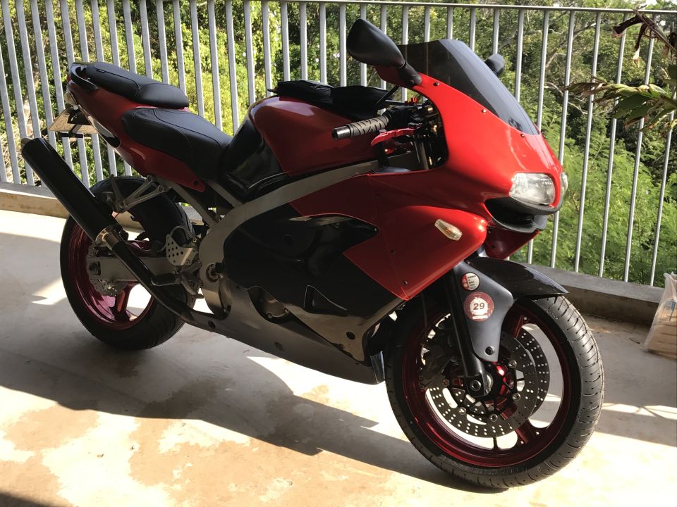 Red and black sport motorcycle parked on a patio.