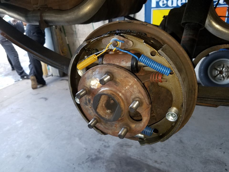 Close-up of a vehicle's drum brake assembly with springs and brake shoes.