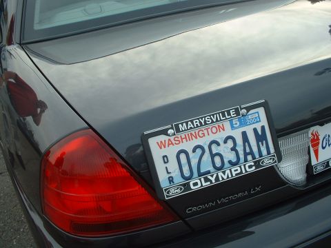1999 Ford Crown Victoria - The rear of a Ford Crown Victoria LX is shown, a Washington state license plate and a reflection in the trunk lid.