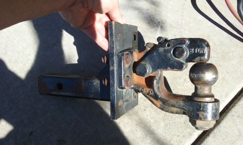 1995 Ford Bronco - Trailer hitch ball mount with 8 TON rating, held by a hand against a concrete surface.