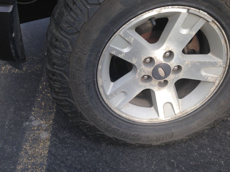 Close-up of a silver 5-spoke wheel with a tire