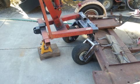 1995 Ford Bronco - An engine hoist is positioned on a trailer, with one side resting on jack stands.