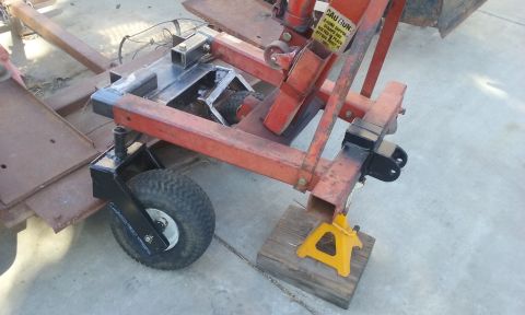 1995 Ford Bronco - A trailer hitch assembly is shown with a jack stand supporting it and a small wheel attached.