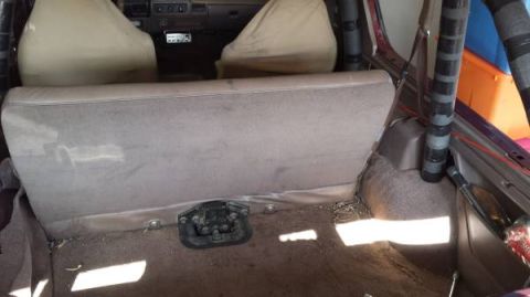 1996 Ford Bronco - The interior of a vehicle shows the rear seats and cargo area, with visible padding on a roll cage.