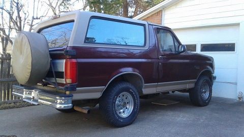 1996 Ford Bronco - This 1996 Ford Bronco is parked in front of a garage with a spare tire on the back.