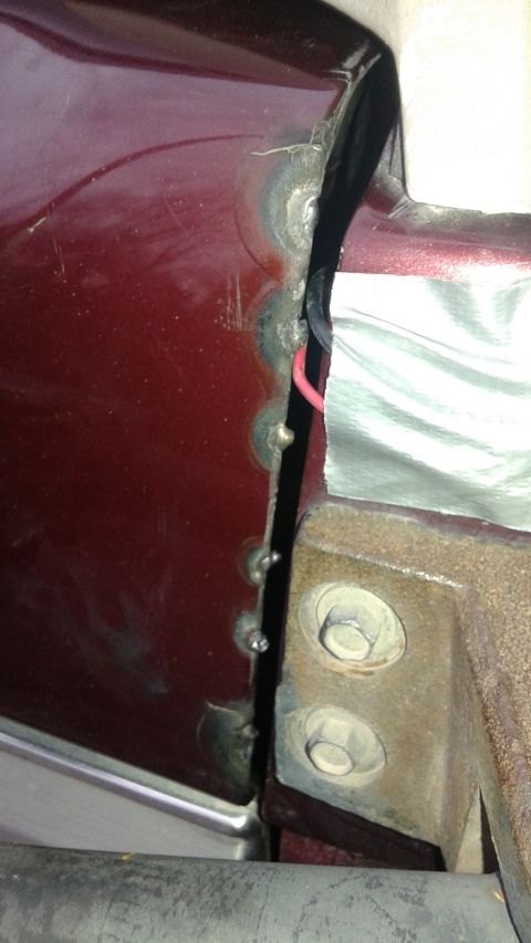 1996 Ford Bronco - Detail of a car's bodywork reveals welding and wiring near the door seam.