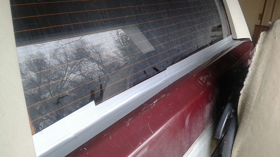 Rear window and maroon quarter panel of a vehicle
