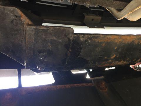 1996 Ford Bronco - Close-up view of heavily rusted frame and suspension parts, with visible bolts and brackets.