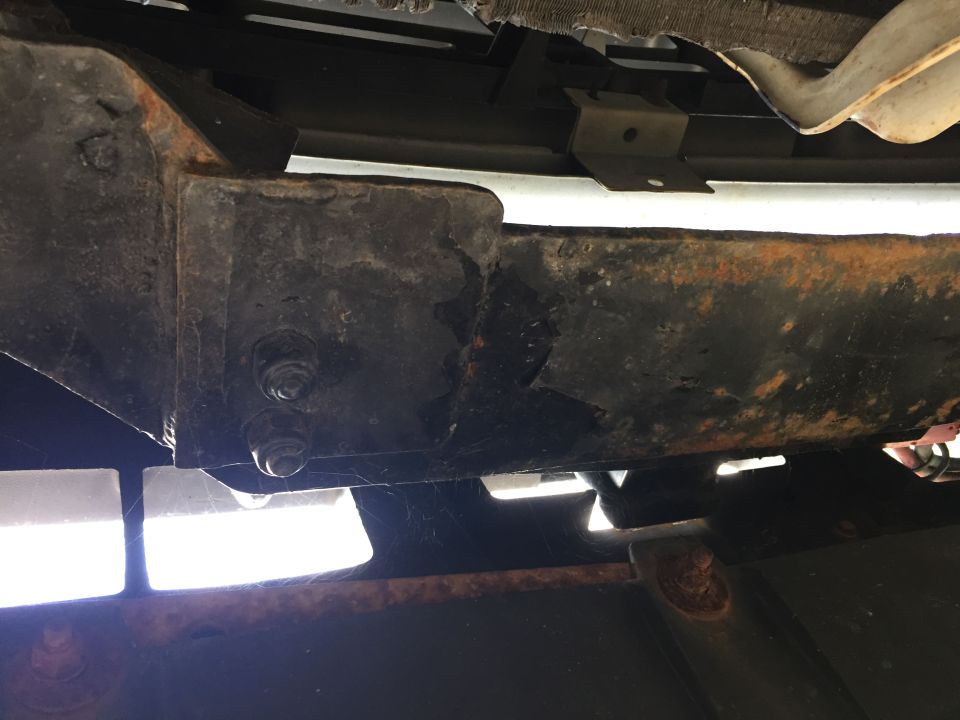 Rusted frame and suspension components with visible bolts and brackets