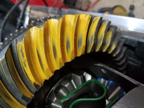 1995 Ford Bronco - Close-up of a ring and pinion gear showing yellow marking compound indicating wear patterns.