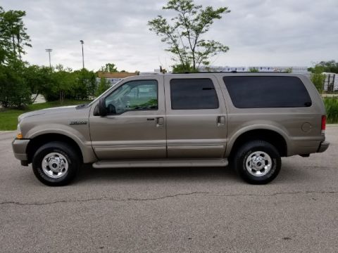 2003 Ford Excursion - This large SUV is shown from the side, parked on a paved surface with trees and buildings in the background.