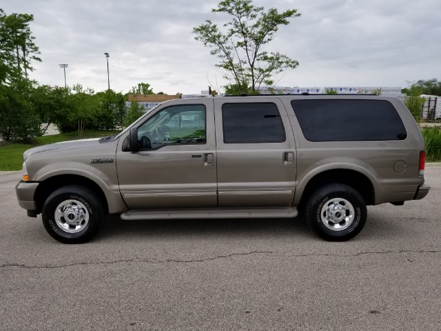 Side view of a tan 2003 Ford Excursion SUV parked on asphalt