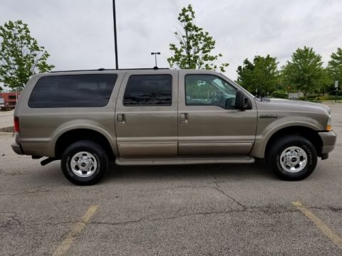 2003 Ford Excursion - Side profile of a tan 2003 Ford Excursion parked outdoors.