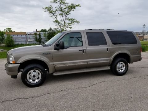 2003 Ford Excursion - Tan Ford Excursion SUV with tinted windows and chrome wheels is viewed from the side.