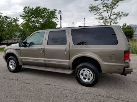 2003 Ford Excursion - Side view of a tan 2003 Ford Excursion parked on asphalt.
