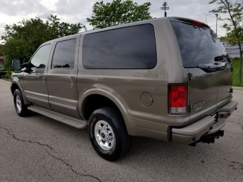 2003 Ford Excursion - Rear view of a tan 2003 Ford Excursion parked on asphalt.