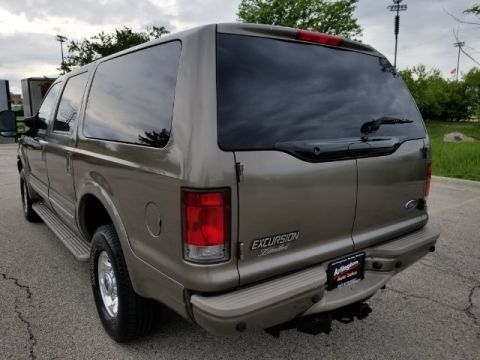 2003 Ford Excursion - The rear of a tan Ford Excursion SUV is shown, with tinted windows and a license plate frame from Arlington Auto Sales.
