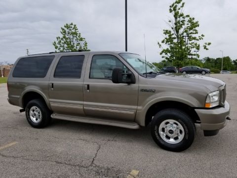 2003 Ford Excursion - A tan Ford Excursion is parked in a lot under a cloudy sky.