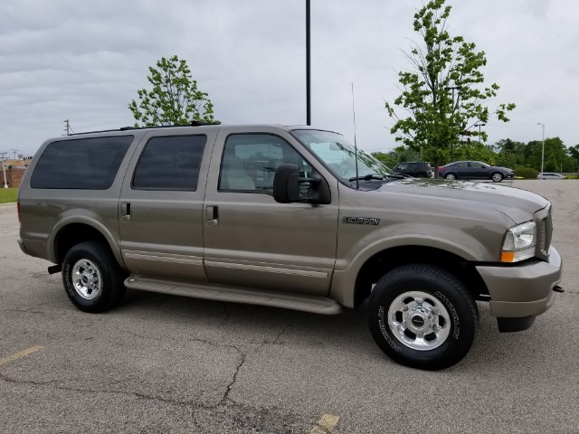 Tan Ford Excursion parked on asphalt, side view. It's a 2003 model