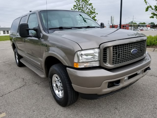 Brown Ford Excursion SUV parked on asphalt, front 3/4 view. Visible text: SUPERMOTORS