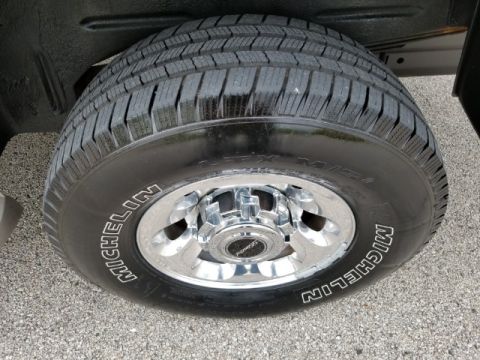 2003 Ford Excursion - A close-up view of a vehicle's tire and chrome wheel, showing the Michelin branding on the tire sidewall.
