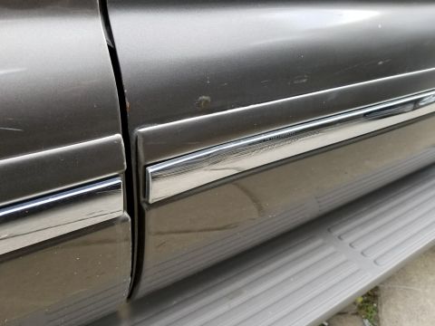 2003 Ford Excursion - Close-up of the side body molding on a 2003 Ford Excursion, showing the chrome trim detail.