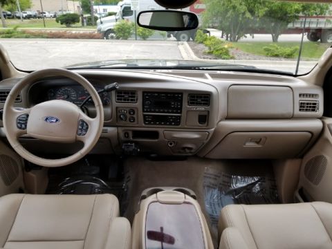 2003 Ford Excursion - The interior of a 2003 Ford Excursion features a tan dashboard, steering wheel, and leather seats.